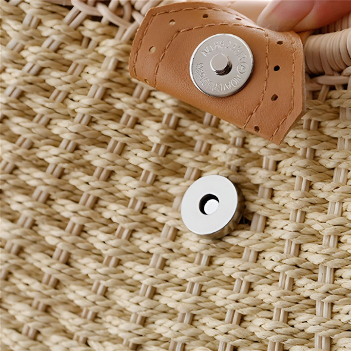 Gros plan sur le fermoir magnétique d'un sac en paille tissée avec patte en cuir., 46193945706720,46193945739488,46193945772256,46193945805024,46193945837792
