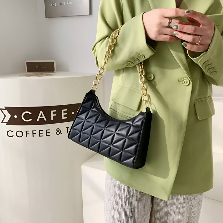 Femme avec blazer vert tenant un sac à main noir matelassé à chaîne dorée devant un café., 46193937350880,46193937383648,46193937416416