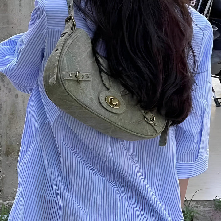 Chemise rayée bleue/blanche et sac bandoulière gris portés par une personne de dos., 46193944166624