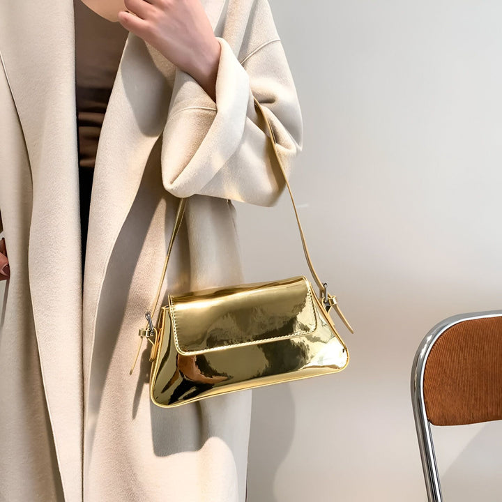 Sac à bandoulière doré brillant porté avec un manteau beige., 46194032705760