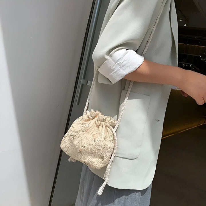 Personne portant un blazer vert clair et un petit sac beige à cordon., 46193944494304,46193944527072,46193944559840