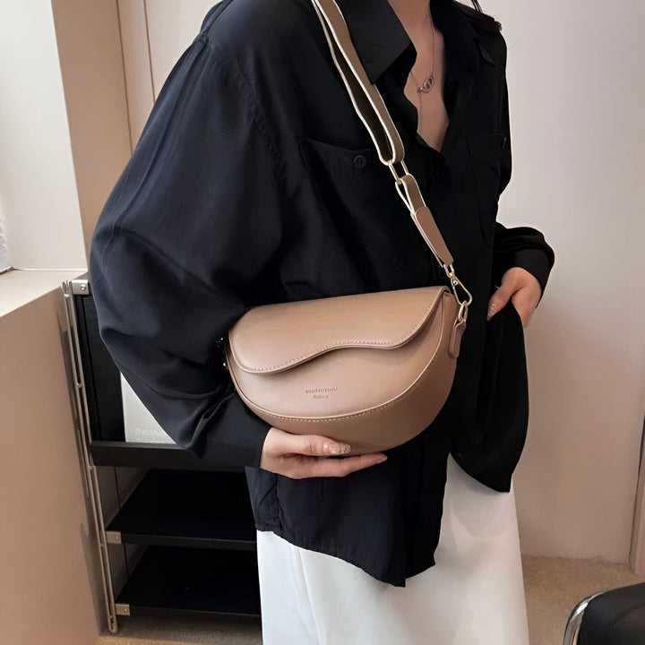 Sac à main demi-lune marron clair porté par une personne., 46194067079392,46194067112160,46194067144928