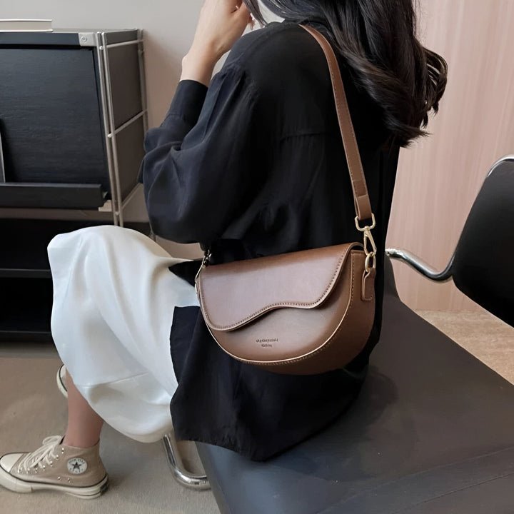 Sac selle marron porté en bandoulière., 46194067079392,46194067112160,46194067144928