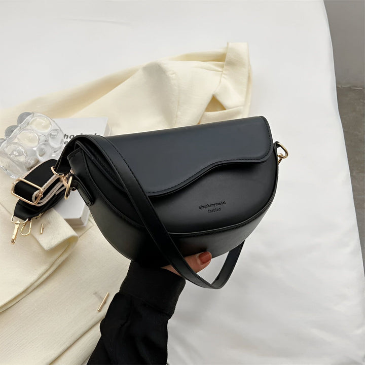 Sac bandoulière noir en demi-lune tenu par une main., 46194067079392,46194067112160,46194067144928