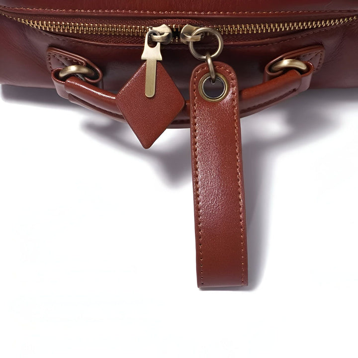 Gros plan sur la fermeture éclair et les tirettes en cuir marron d'un sac, 46193860182240,46193860215008