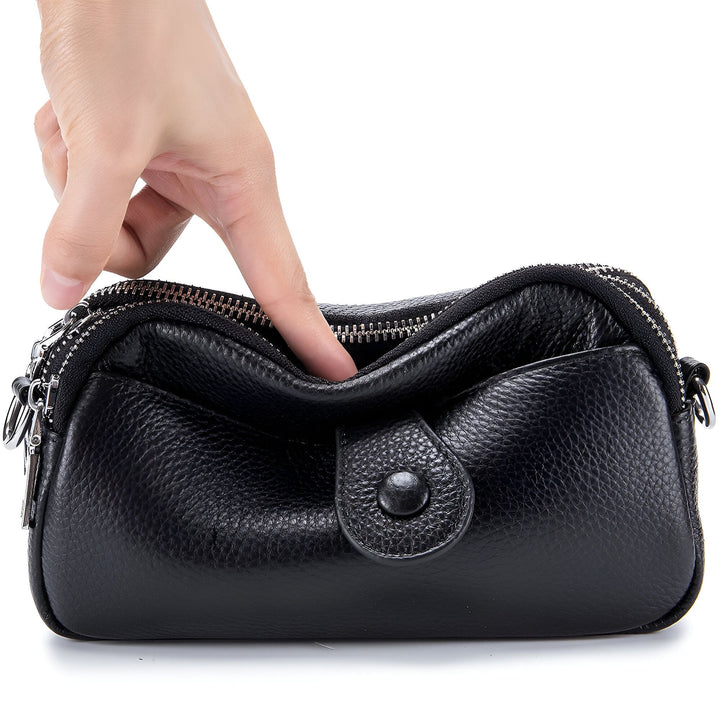 Main ouvrant un sac à main noir en cuir zippé, 46194062459104,46194062491872,46194062524640,46194062557408,46194062590176