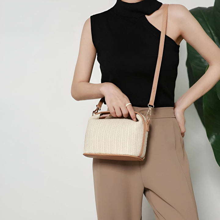 Femme portant un petit sac tissé beige avec sangle marron et un haut noir, 46194030674144