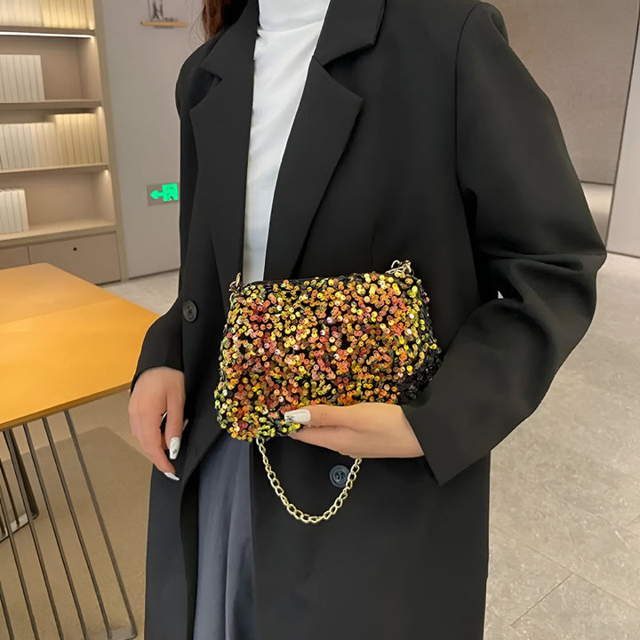 Femme tenant un petit sac à sequins multicolores avec chaîne dorée, portant un blazer noir., 46194028216544,46194028249312,46194028282080,46194028314848