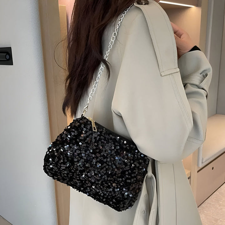 Personne portant un sac pochette noir à sequins avec bandoulière chaîne argentée., 46194028216544,46194028249312,46194028282080,46194028314848