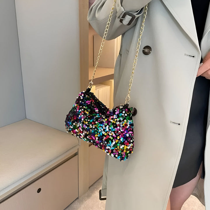 Sac à main multicolore scintillant à sequins avec chaîne dorée porté par une personne en trench-coat., 46194028216544,46194028249312,46194028282080,46194028314848