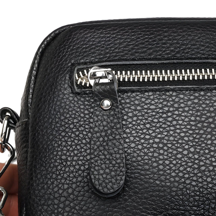 Gros plan sur sac en cuir noir grainé avec fermeture éclair argentée et rivet., 46194065080544,46194065113312,46194065146080,46194065211616,46194065244384