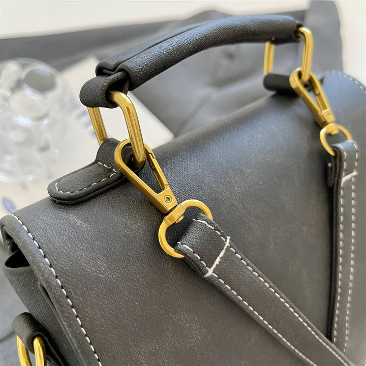 Détail anse et fermoir doré sur sac cuir noir surpiqué blanc., 46193901863136,46193901895904,46193901928672