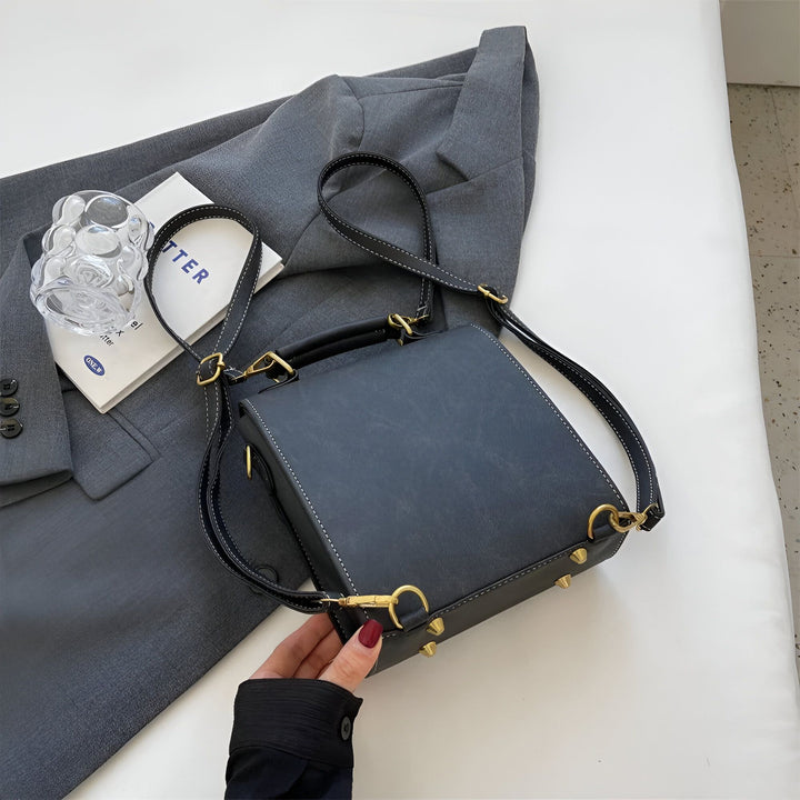 Sac bandoulière structuré noir, surpiqûres blanches, clous et boucles dorés., 46193901863136,46193901895904,46193901928672