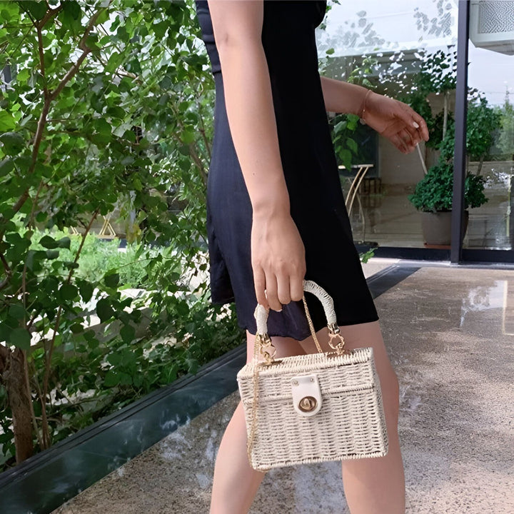 Femme en robe noire tenant un sac à main rectangulaire en osier blanc., 46193945215200,46193945247968,46193945280736