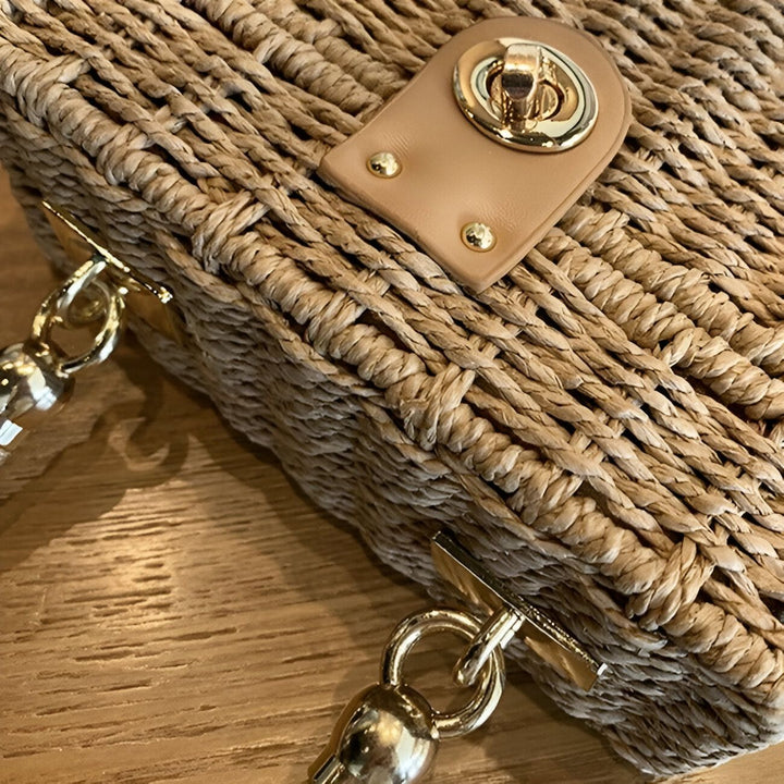 Gros plan sur un sac en paille tressée avec fermoir doré et attaches., 46193945215200,46193945247968,46193945280736
