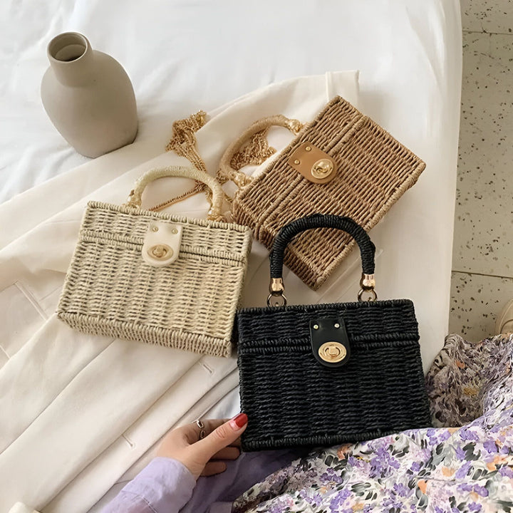 Trois sacs à main tressés en paille de couleurs beige, marron clair et noir sur un tissu blanc., 46193945215200,46193945247968,46193945280736