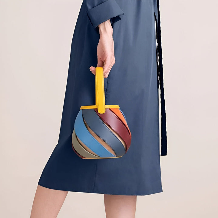 Femme tenant un sac à main rond multicolore en cuir avec anse jaune., 46193872994528,46193873027296,46193873060064,46193873092832