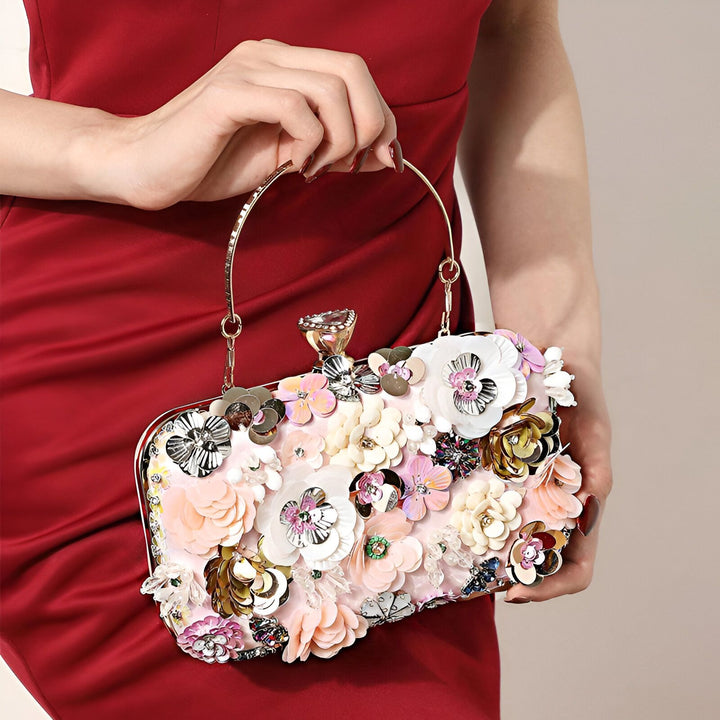 Pochette rose brodée de fleurs, sequins et perles colorées tenue par une femme., 46193927356640,46193927389408,46193927422176