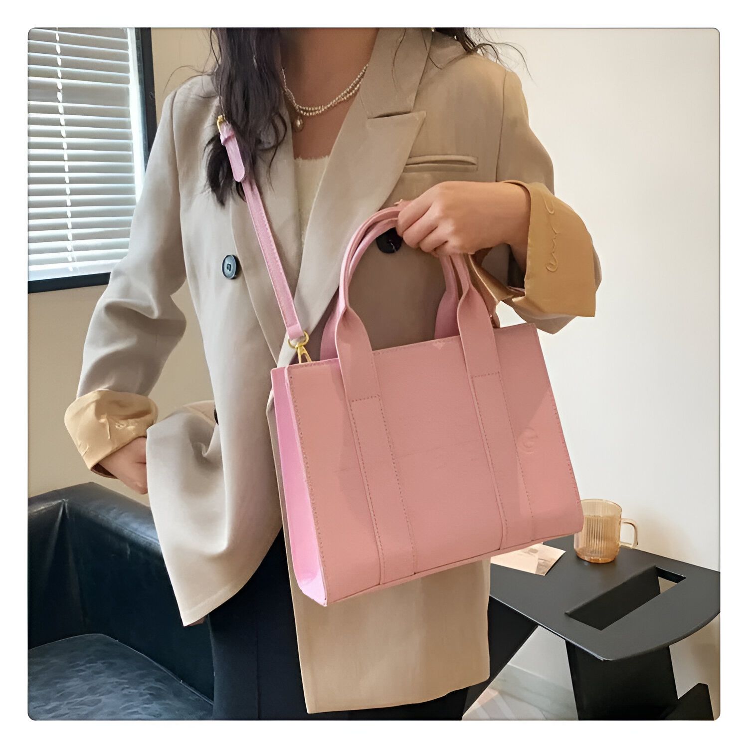 Une femme portant un blazer beige porte un sac à main rose avec une bandoulière.  Le sac à main a une texture en cuir croco.