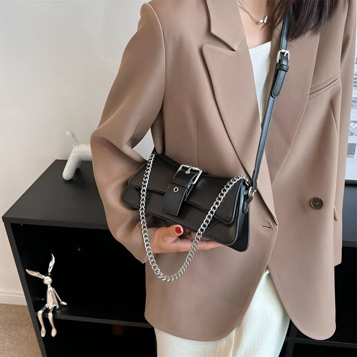 Sac noir avec bandoulière chaîne et boucle, porté par une personne., 46193944297696,46193944330464