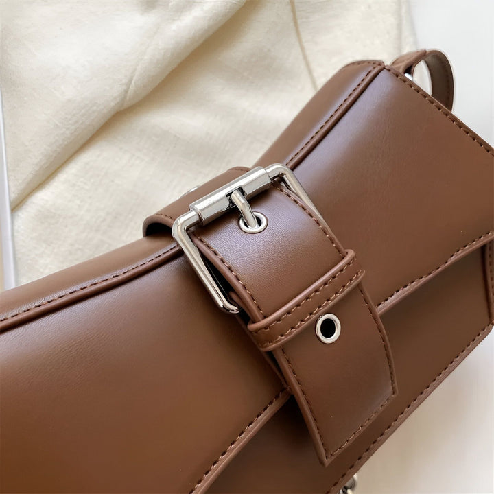 Gros plan sur un sac en cuir marron avec boucle ardillon argentée et sangle, 46193944297696,46193944330464