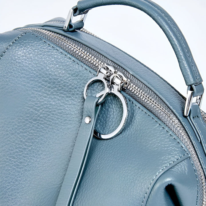 Détail de sac à dos en cuir bleu avec fermeture éclair, tirettes et anse., 46193847599328,46193847632096,46193847664864,46193847697632,46193847730400