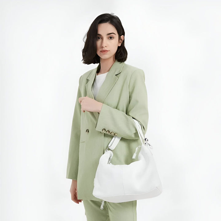 Femme en costume vert tenant un sac à main blanc., 46193844814048,46193844846816,46193844879584,46193844912352