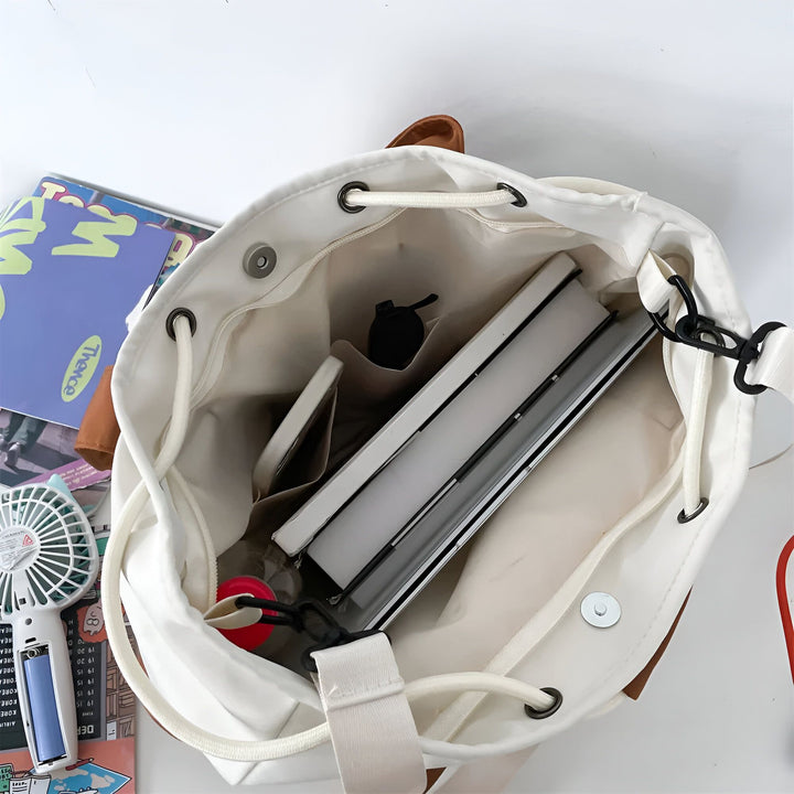 Vue plongeante sur l'intérieur d'un sac à cordon blanc rempli de livres et d'objets., 46193874927840,46193874960608