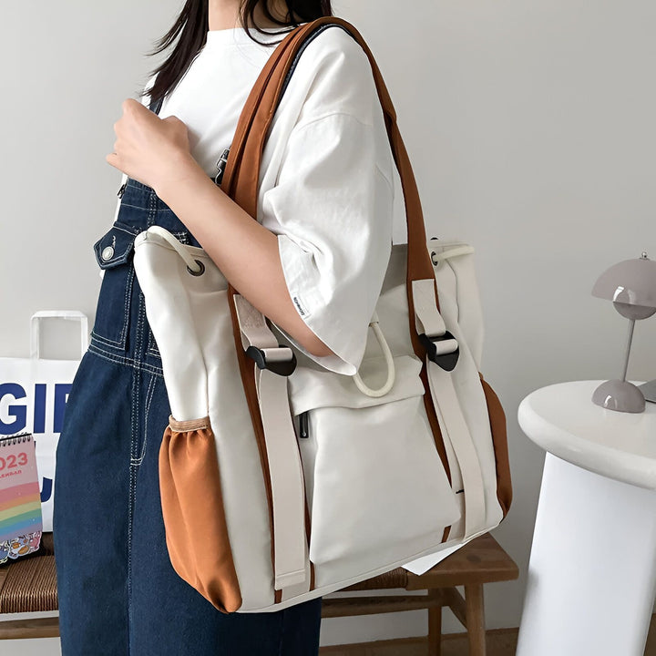 Personne portant une salopette en jean et t-shirt blanc, tenant un grand sac cabas en toile blanc et marron., 46193874927840,46193874960608