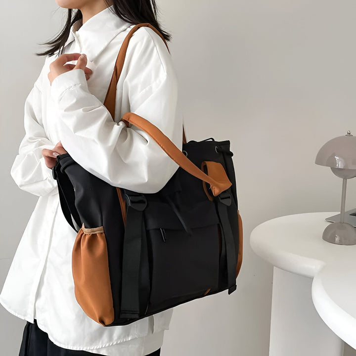 Sac tote noir et marron porté à l'épaule., 46193874927840,46193874960608