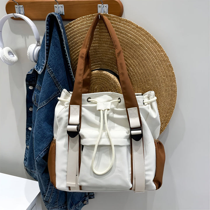 Casque, veste en jean, chapeau de paille et sac cabas blanc/marron accrochés sur un porte-manteau., 46193874927840,46193874960608