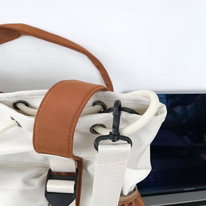 Détail d'un sac blanc avec bretelles marron, cordon de serrage et sangle blanche ajustable avec boucle et crochet., 46193874927840,46193874960608