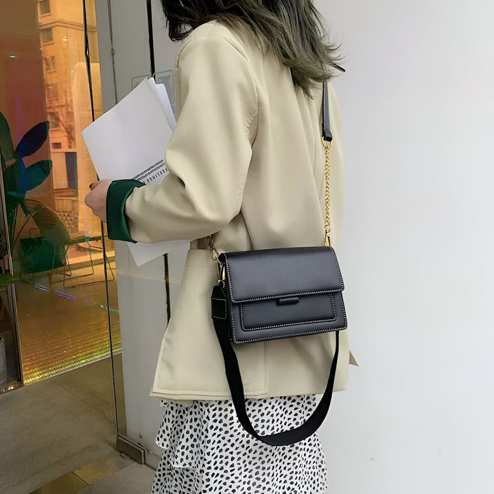 Personne en blazer beige et jupe tachetée, portant un sac à main noir avec chaîne dorée., 46193877221600,46193877254368,46193877287136,46193877319904