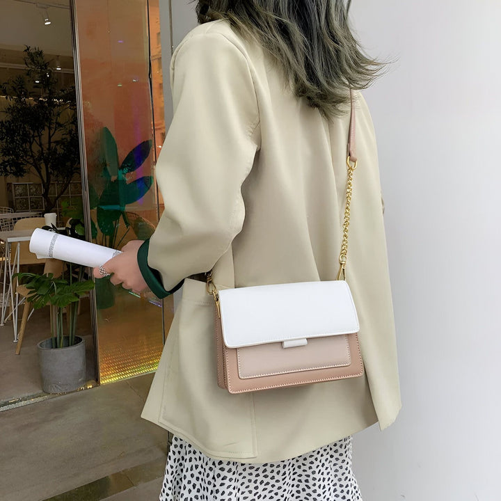 Sac bandoulière blanc et beige chaîne dorée porté par femme en veste claire., 46193877221600,46193877254368,46193877287136,46193877319904