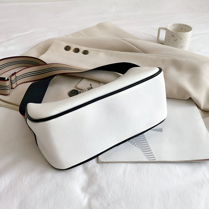 Sac blanc en cuir avec bandoulière rayée posé sur une veste beige et une tasse., 46266441433312,46266441466080,46266441498848