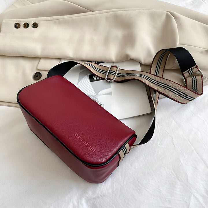 Sac bandoulière rectangulaire rouge avec sangle rayée sur fond clair., 46266441433312,46266441466080,46266441498848