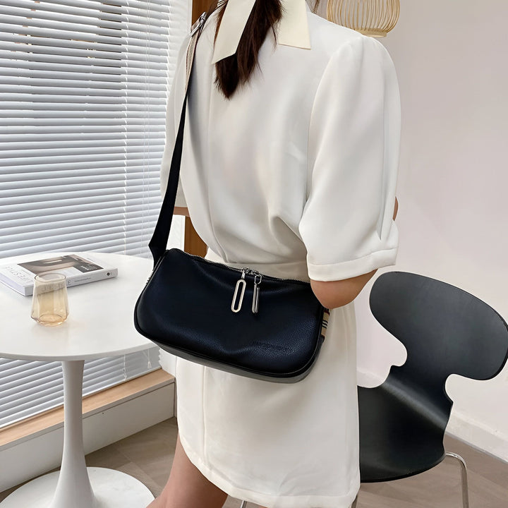 Femme portant un sac bandoulière noir texturé avec zips argentés., 46266441433312,46266441466080,46266441498848