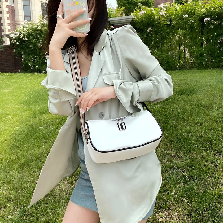 Femme tenant un sac à main blanc et portant une veste vert pâle., 46266441433312,46266441466080,46266441498848