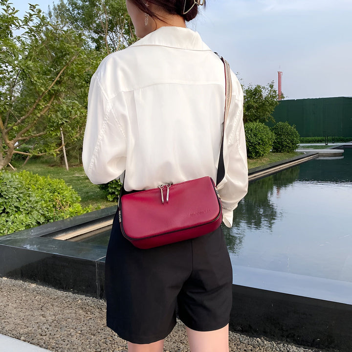 Vue de dos d'une personne en chemise blanche et short noir avec un sac rouge bordeaux., 46266441433312,46266441466080,46266441498848