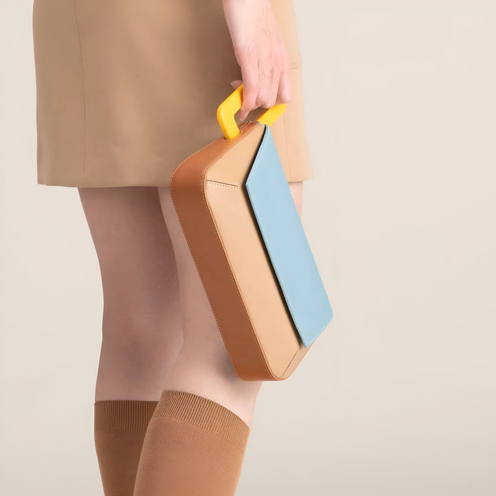 Sac à main géométrique marron, bleu clair et jaune porté par une personne., 46193873715424,46193873748192,46193873780960,46193873813728,46193873846496