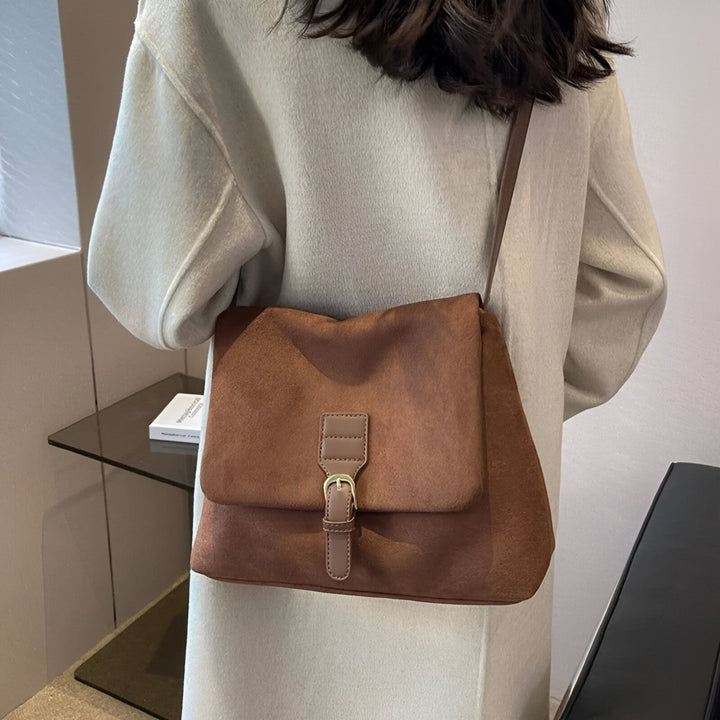 Sac à bandoulière marron effet suédine avec boucle porté sur un manteau clair, 46193887510752,46193887543520