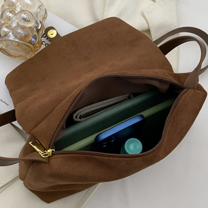 Sac en daim marron ouvert contenant un téléphone, un livre et un petit objet, 46193887510752,46193887543520
