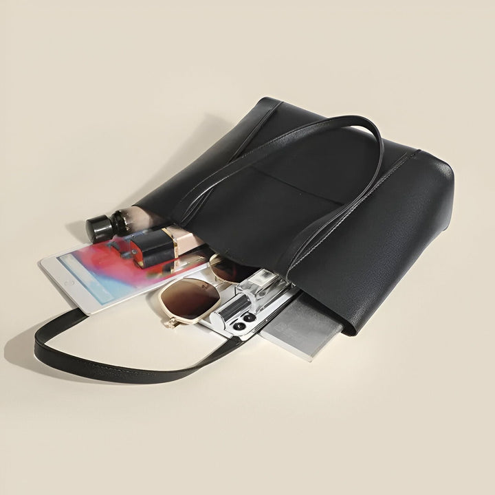Sac tote noir ouvert avec tablette, lunettes, parfum, maquillage à l'intérieur., 46194055643360
