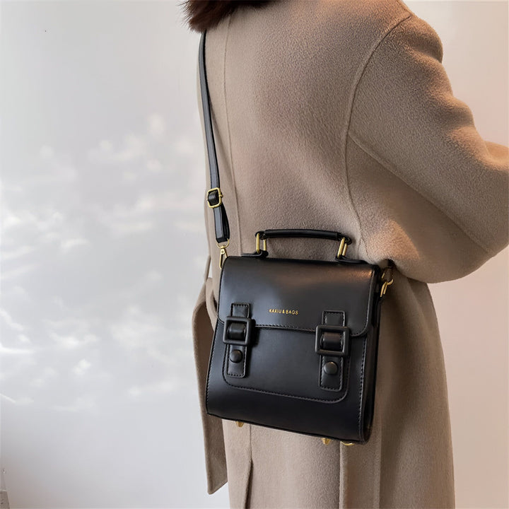 Sac noir à bandoulière KAXIU & BAGS avec boucles, porté par une personne en manteau beige., 46194003312864,46194003345632,46194003378400,46194003411168