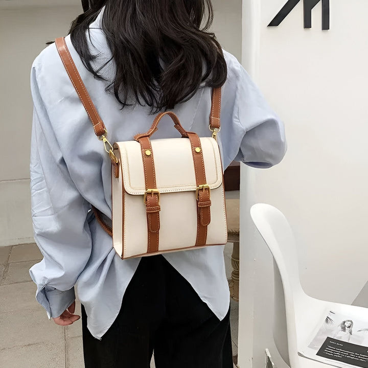 Petit sac à dos blanc de style cartable avec boucles marron porté par une personne en chemise bleue., 46193899569376,46193899602144,46193899634912
