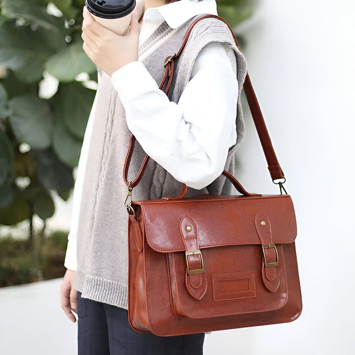 Sac besace marron porté à l'épaule par une personne tenant un café., 46193905008864,46193905041632