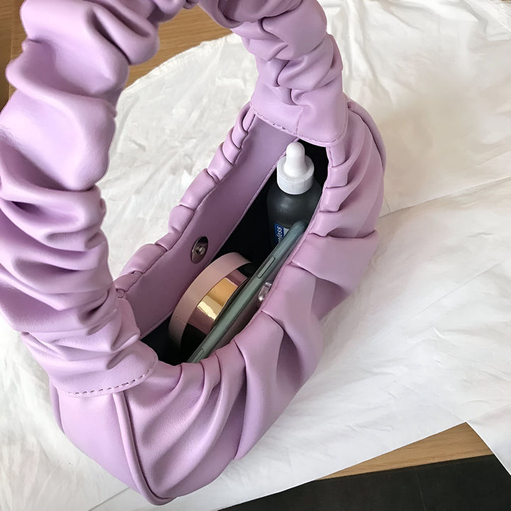 Sac à main violet clair en cuir froissé, ouvert, avec téléphone et maquillage visibles à l'intérieur., 46193963401440,46193963434208,46193963466976,46193963499744,46193963532512