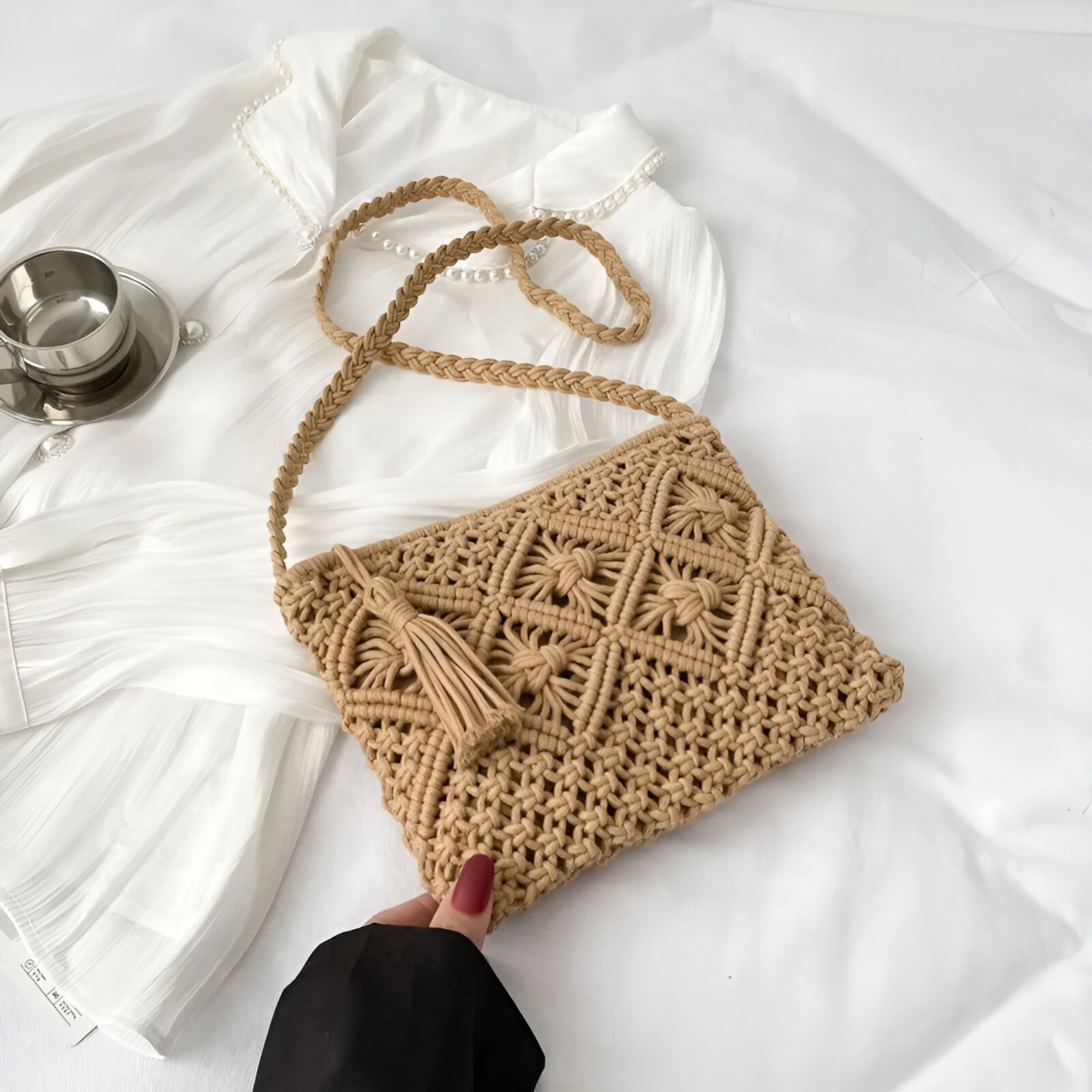 Un sac à main en macramé beige avec une bandoulière.