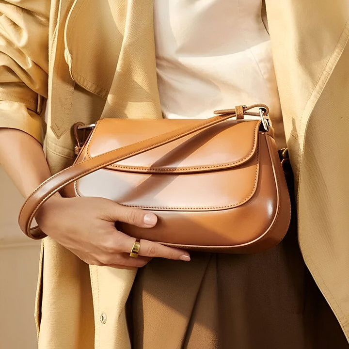 Sac à bandoulière en cuir camel porté avec un manteau beige., 46193854316768,46193854349536
