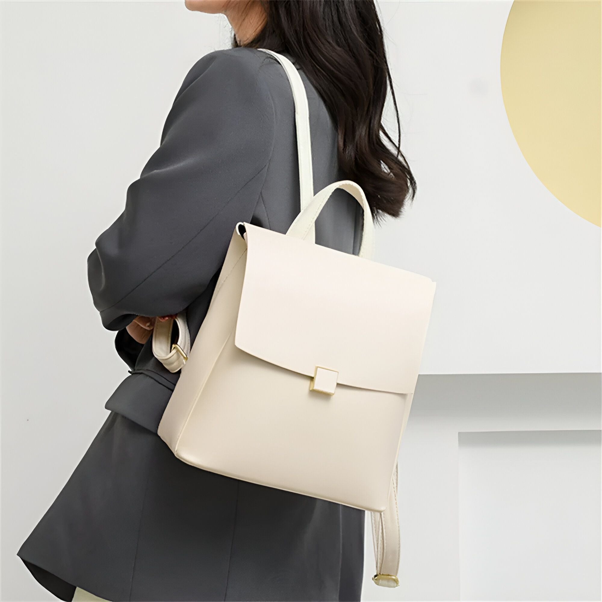 Une femme portant un sac à dos en cuir blanc cassé.